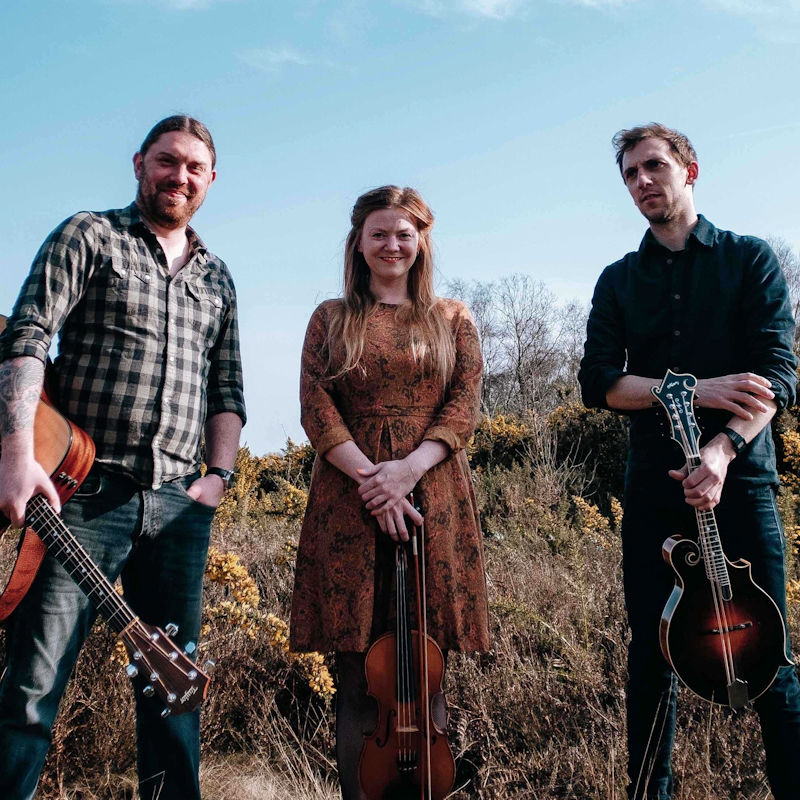 The Shackleton Trio - Deepdale Festival | 26th to 29th September 2024 - <p>Captivating songwriting and fiery tunes that combine mandolin, fiddle, guitar and banjo with powerful three part harmonies. The unmistakable sound of The Shackleton Trio brings to life the stories of their native East Anglia, and beyond.</p>

<p>September 2024 sees the band touring a brand new album, as they look ahead to celebrating their 10 year anniversary in 2025. The trio features Georgia Shackleton (fiddle, vocals), Aaren Bennett (guitar) and Nic Zuppardi (mandolin and banjo). Collectively the band draw influence from British, American and Scandinavian folk traditions, whilst Georgia's flair for sourcing largely unsung material from East Anglia keeps the band firmly rooted in their local tradition.</p>

<p>Almost a decade performing together has seen the band played on BBC Radio 2, Radio 3 and Radio 4, BBC 6 Music, RTE 1, BBC Countryfile, press coverage gleaming  reviews, an appearance on Cambridge Folk Festival's prestigious main stage, a host of UK and European festivals and international tours, and many miles in the Mondeo. This is a band that clearly enjoys playing together, and are not to be missed.</p>